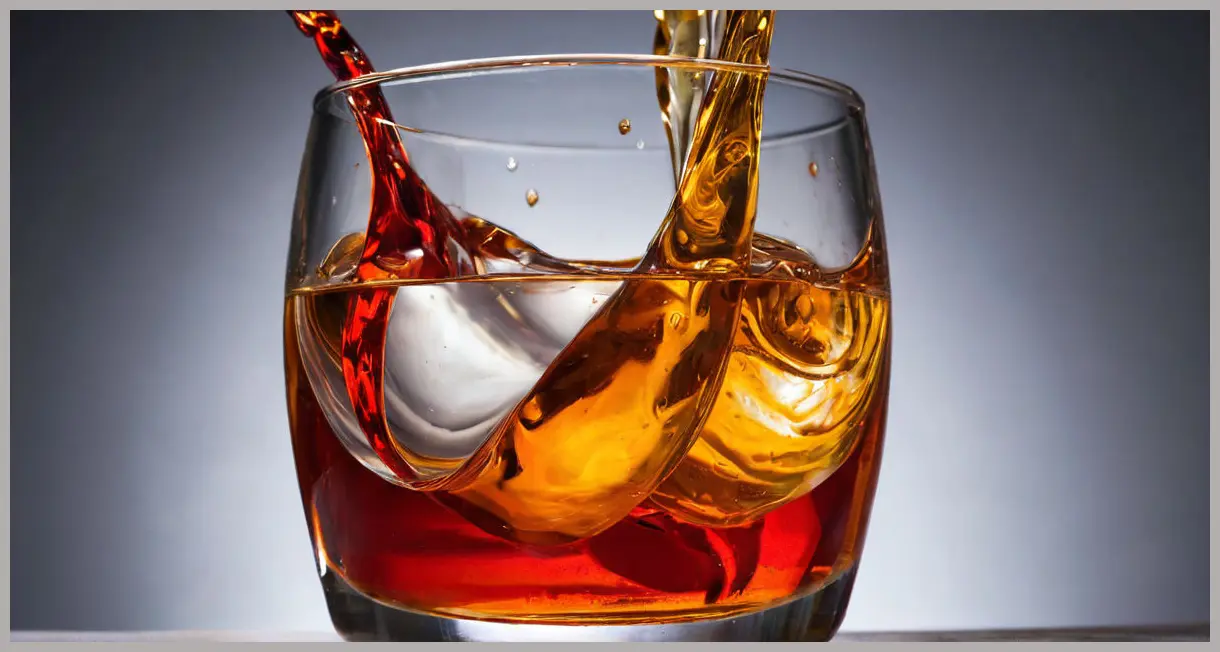 A photorealistic, abstract close-up of the swirling, translucent amber and ruby liquids of a Whisky Aperol hot toddy, illuminated by dynamic studio light.