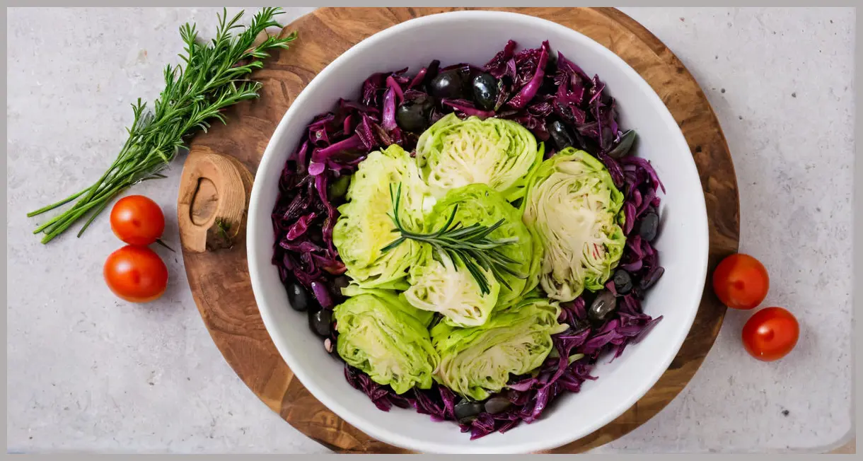 Overhead view of vegan cabbage cacciatore in a white bowl, cabbage wedges arranged with olives, capers, and rosemary, soft studio lighting and earthy tones.