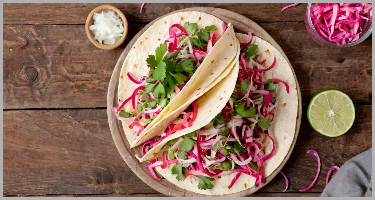 Taco slaw with pink pickled onions in overhead flat lay, rustic wooden table, soft studio light, vibrant colors, fresh cilantro garnish.