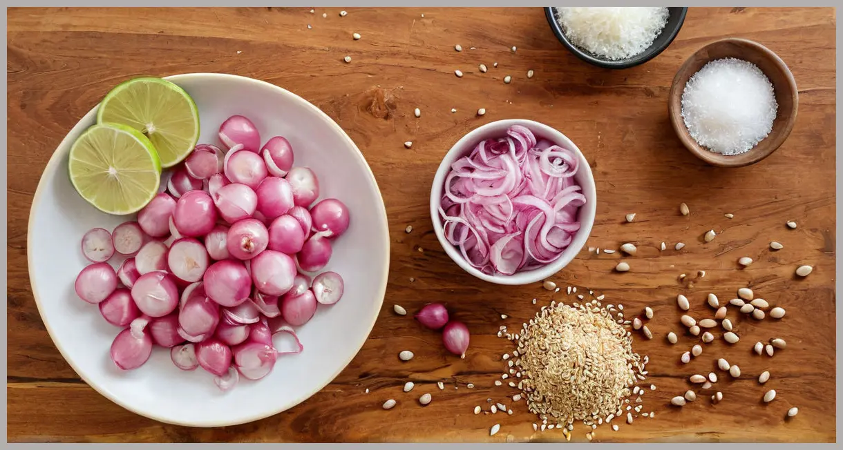 Overhead shot of pink pickled onions, lime halves, garlic, and cumin seeds on a wooden table, golden hour lighting.