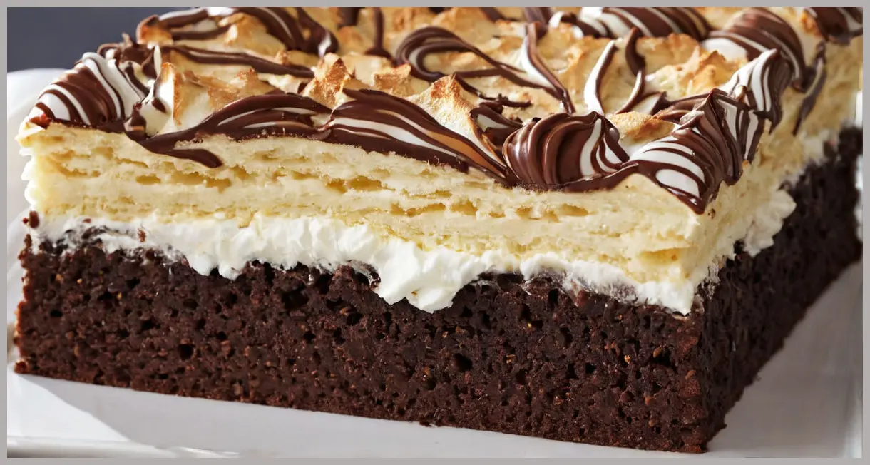 Macro shot of a single Tunnock’s teacake traybake square lifted from the tray, revealing its crispy biscuit, fluffy meringue, and glossy chocolate layers under dramatic side lighting.