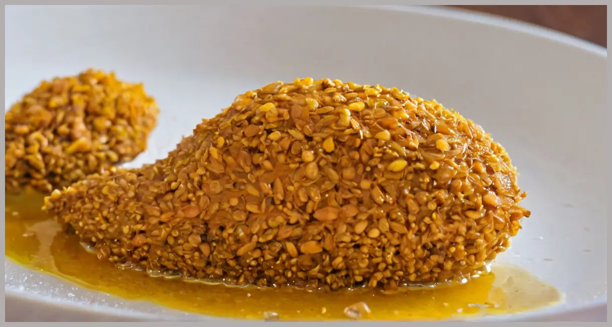 A single glistening piece of Jackfruit pickle (Kathal achaar) on a white plate, under soft natural light, oil droplets shining.