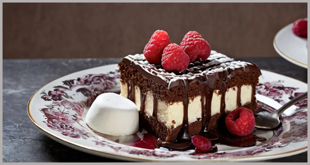 A single slice of chocolate and berry traybake on porcelain, showcasing white chocolate drizzle, marshmallows, and raspberries in dramatic side lighting.