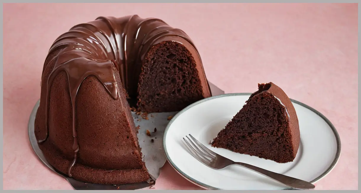 Overhead flat lay of a sliced chocolate bundt cake, soft studio lighting, almond garnish, moist interior revealed. Secret-ingredient chocolate bundt cake