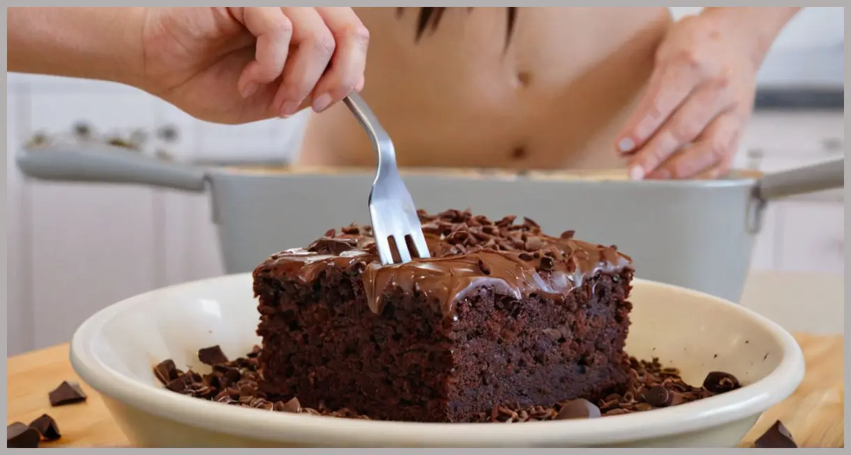 A wide-angle shot of vegan chocolate brownie batter in a mixing bowl, featuring glossy chocolate swirls, chia gel, and vanilla specks under warm kitchen lighting.