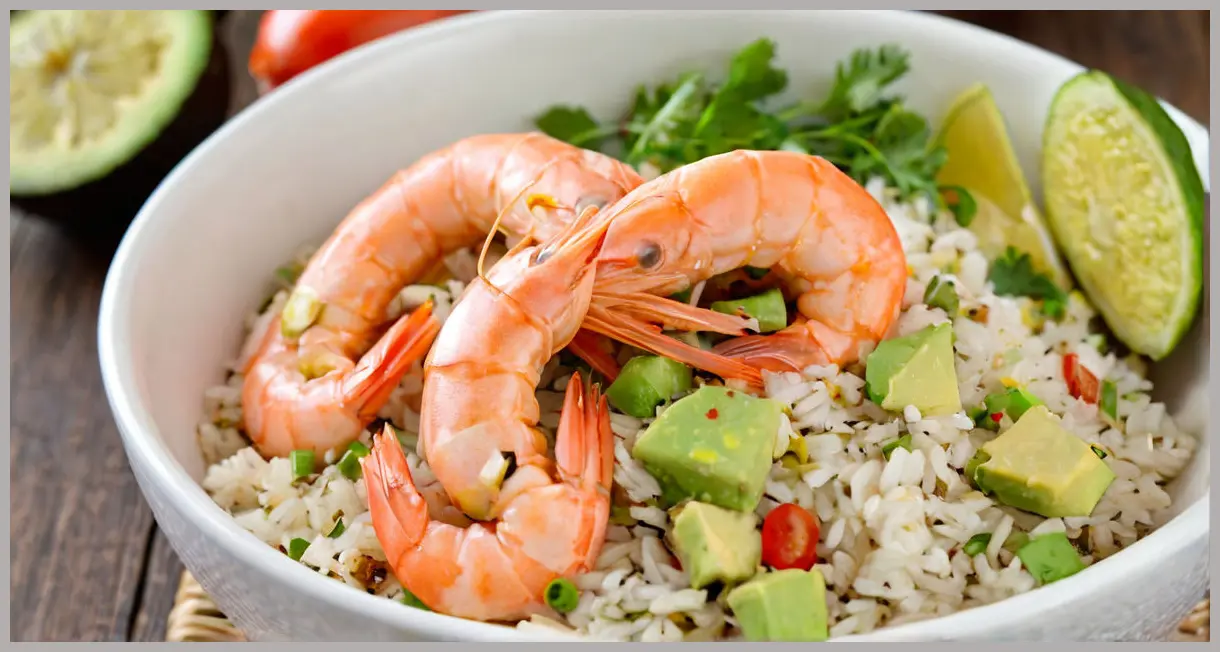 Intimate macro shot of a single prawn on rice, lemon zest glistening, avocado blurred in background. Mexican-style prawn rice with avocado salsa